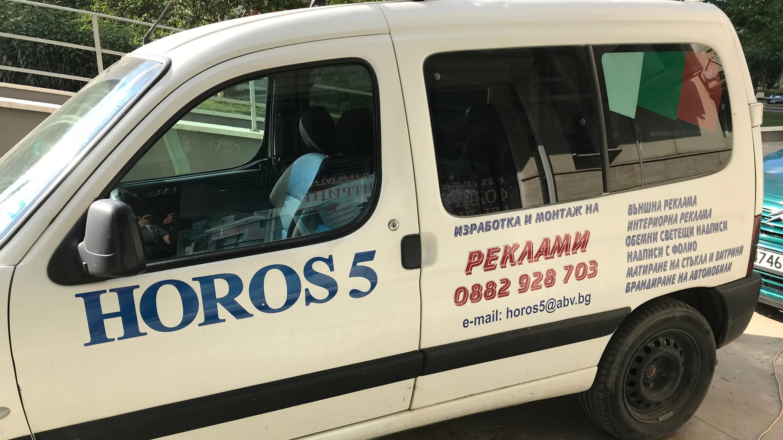 Служебен автомобил на рекламна агенция Хорос 5 в София, брандиран с лого, контакти и рекламни услуги.