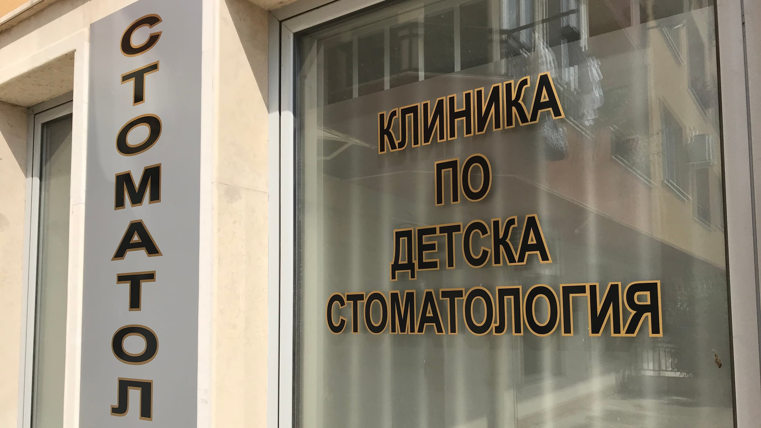 Брандиране на витрина и фасада на дентален център с надписи от фолио 'Клиника по детска стоматология'.