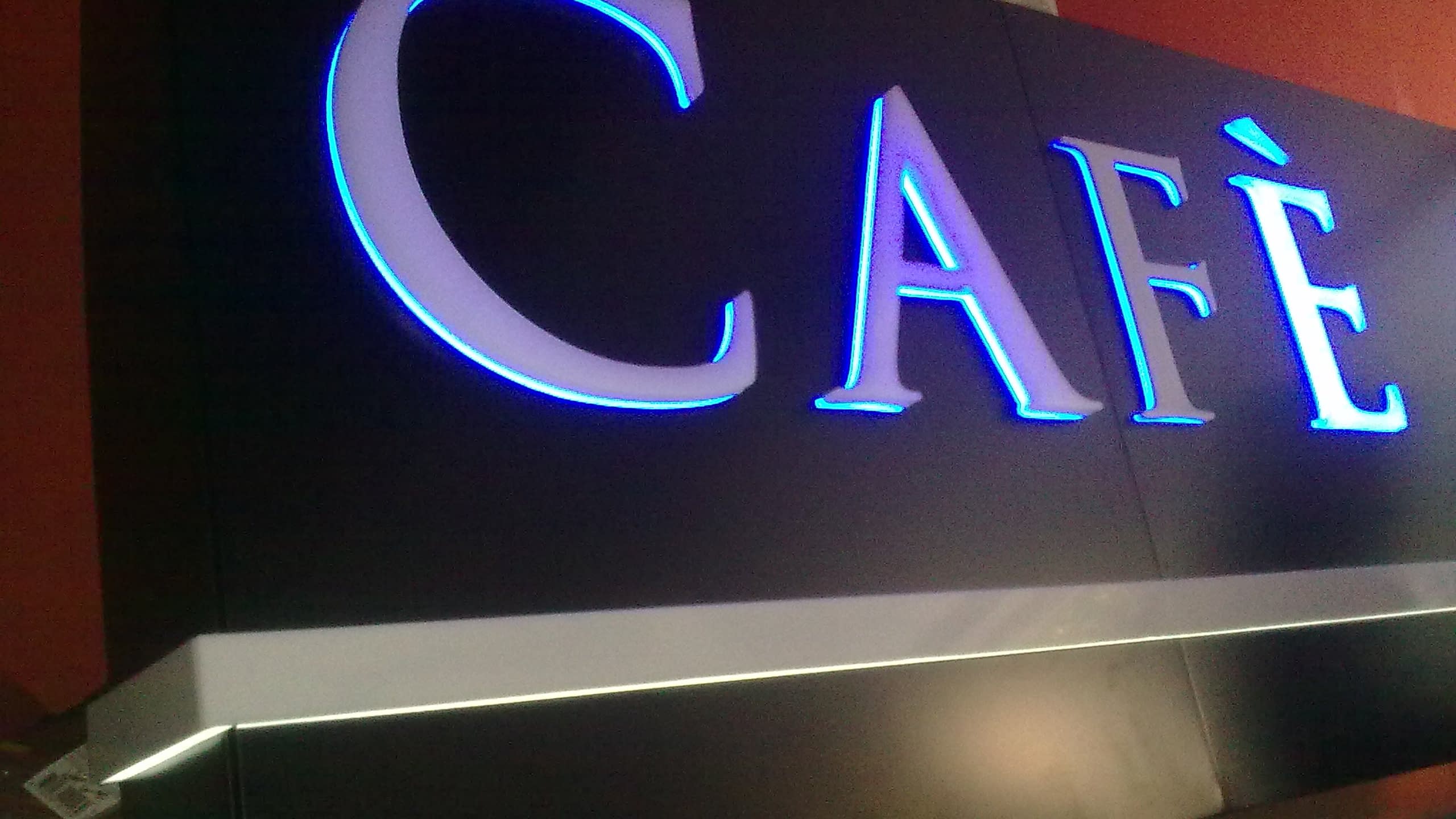 Изработка на елегантна светеща табела "CAFÈ" с обемни букви и синьо контражурно осветление от рекламна агенция в София.