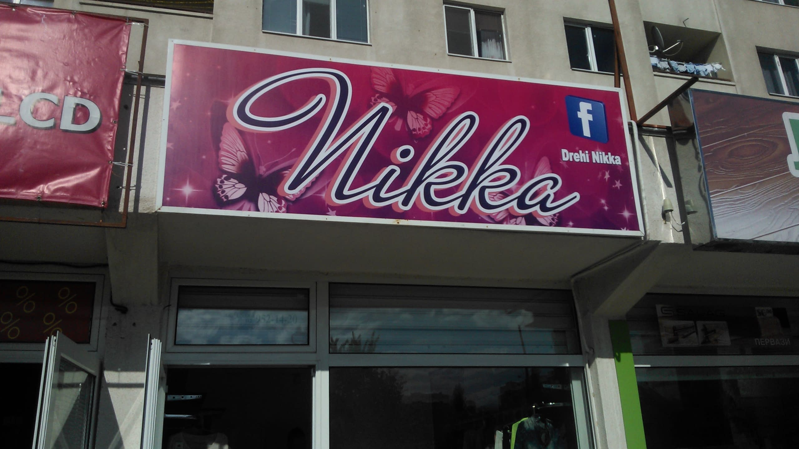 Винилна реклама с пълноцветен печат за магазин за дрехи "Nikka", монтирана на фасада на сграда в София.